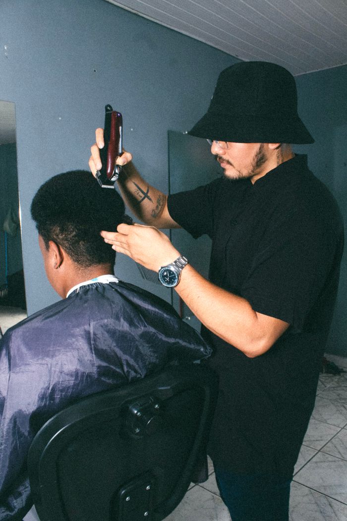 Barber using hair clipper on a customer in a salon. Breves, PA, Brazil.