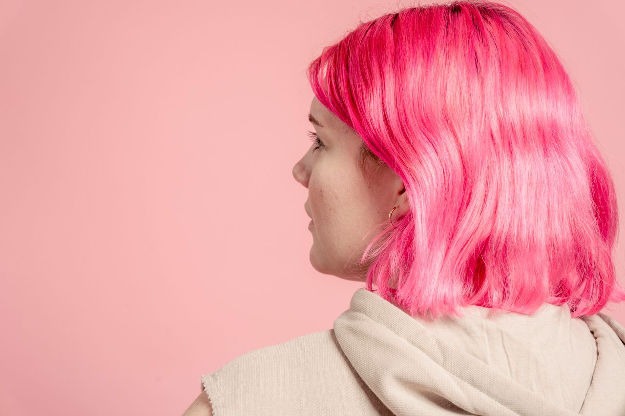 The Art of Drawing Readers In: Your attractive post title goes here Back view of anonymous young female with dyed hair in casual outfit standing on pink background in modern light studio
